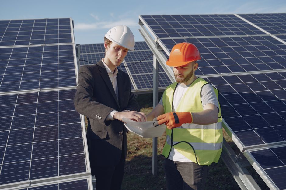 find-a-reliable-solar-energy-system-installer-without-the-sales-pressure-image homeowner reviewing rooftop solar plans with a technician